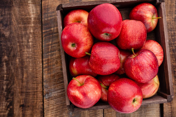 istock Ripe red apples in wooden box. Top view with space for your text. 1360658700