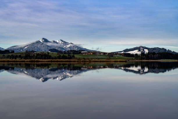the hopfensee at sunrise with reflection of the mountains in the water