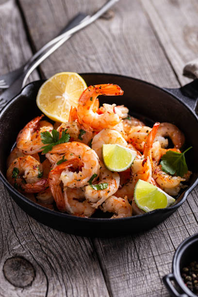 istock Grilled shrimps with greens and garlic in a pan 1360662559