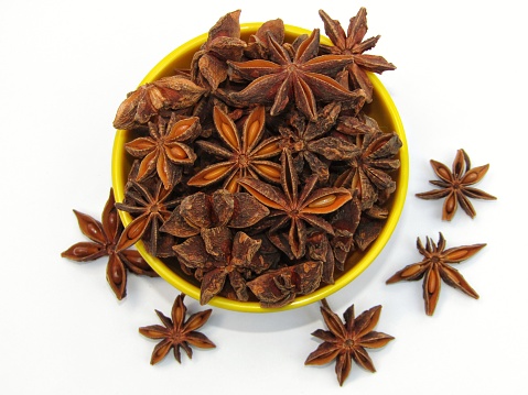 Star anise in a bowl on white background