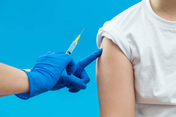 istock Doctor vaccinating for a boy on blue background 1360664303