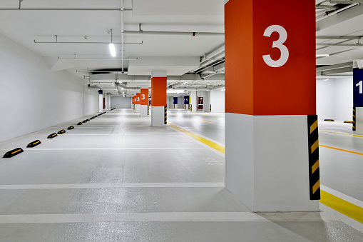 An empty outdoor car park with multiple spaces for cars.