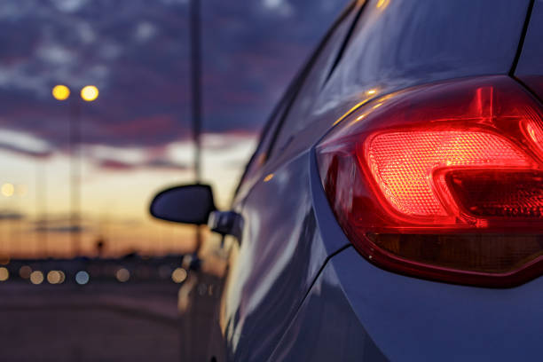 Rear headlight car against defocused background of traffic lights at dusk Alcorcón, Madrid, Spain, Alcorcón, Madrid, Spain, October 21 2021. "nRear headlight car against defocused background of traffic lights at dusk tail light stock pictures, royalty-free photos & images