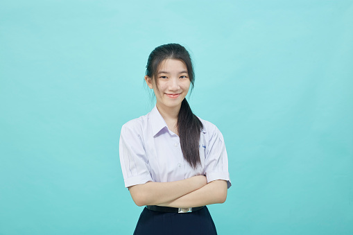 Young Asian student girl high school in student uniform on light blue studio isolated background