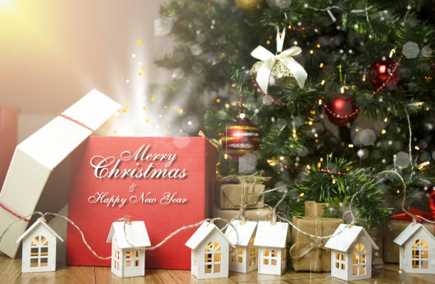 istock Red gift box with congratulatory text on the background of a Christmas tree. 1360668735