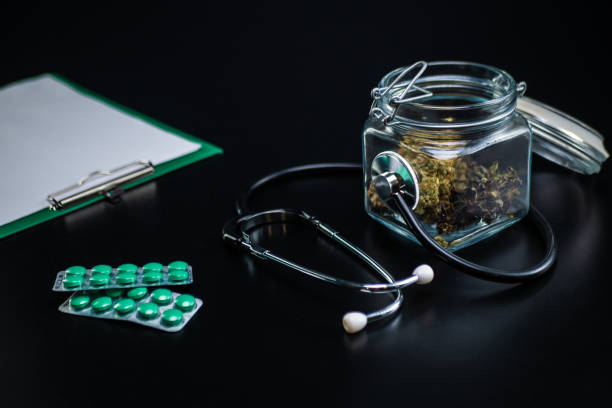 istock Dry medical cannabis in a jar with a stethoscope on a black background 1360669787