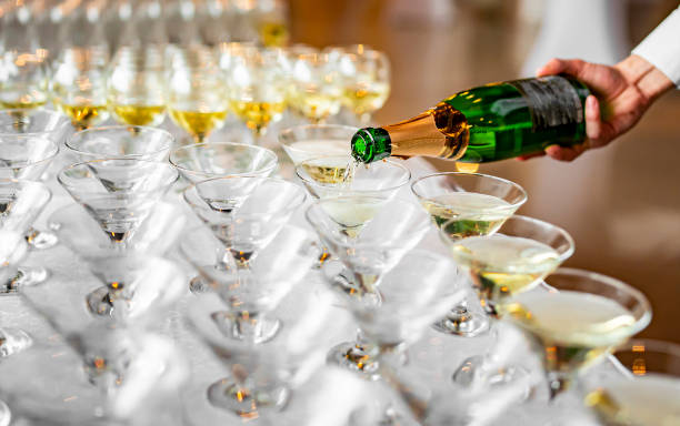 istock waiter pouring champagne wine from bottle in glasses 1360670087