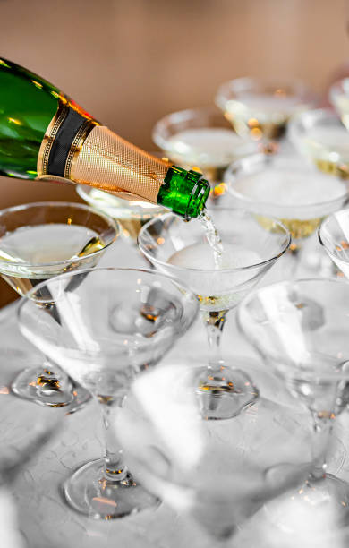 istock waiter pouring champagne wine from bottle in glasses 1360670098