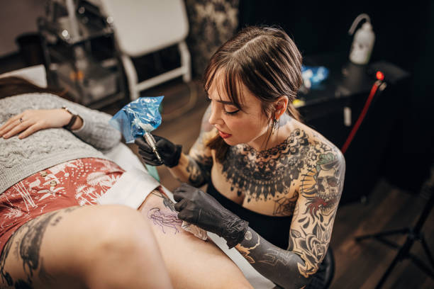 istock Female tattoo artist working 1360670910