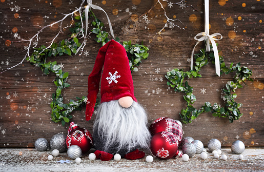Christmas composition with gnome and festive decorations on wooden background. Christmas or New Year greeting card.