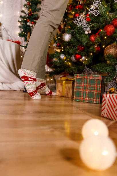 istock Low section of woman standing on tiptoes while decorating the Christmas tree 1360675471