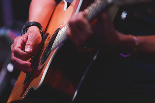 Primer plano de las manos del hombre tocando en la guitarra acústica. photo