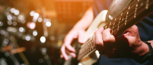 nahaufnahme junger mann, der e-gitarre im aufnahmestudio spielt. rockmusikband. - bass guitar stock-fotos und bilder