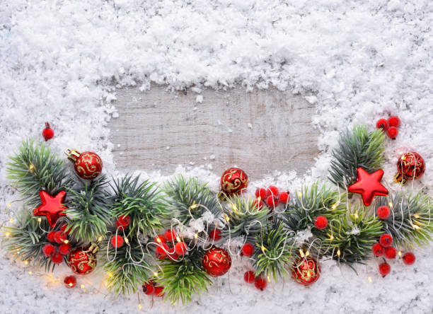 istock Christmas decorations and spruce branches on snow-covered a wooden background. Top view, copy space. Christmas or New Year greeting card. 1360676895