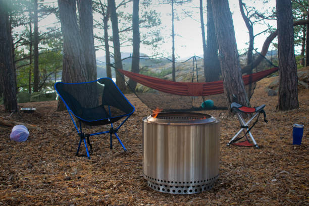 istock Forest Campsite with Fire Pit, Camp Chairs, and Hammock in Stavanger Norway. Camping Theme 1360679038