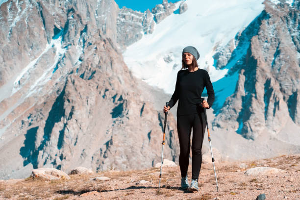 la fille fait de la randonnée dans les montagnes enneigées. - cross coat photos et images de collection