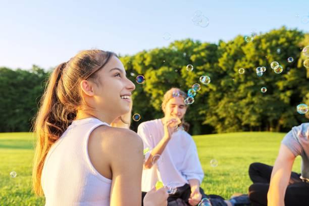 happy teenage girl 13, 14 years old blowing bubbles. - years 13 14 years teenager old imagens e fotografias de stock