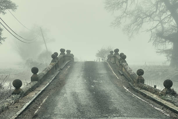 soldados fríos: la espesa niebla helada que envuelve un antiguo puente rural en warwickshire. - suffolk winter england fog fotografías e imágenes de stock