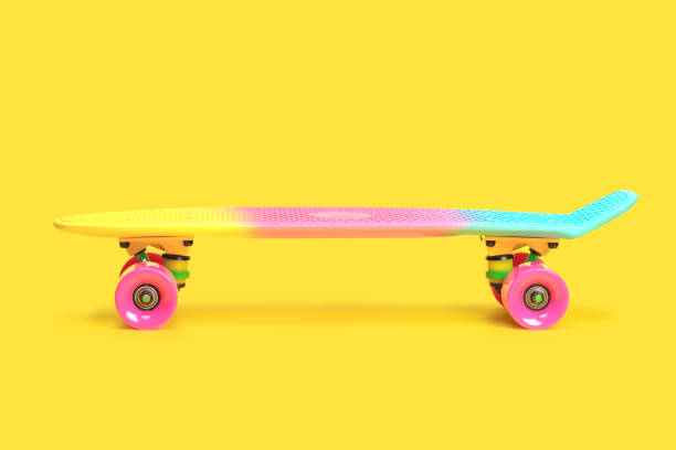 istock rainbow plastic Penny board skateboard isolated on yellow background 1360682336