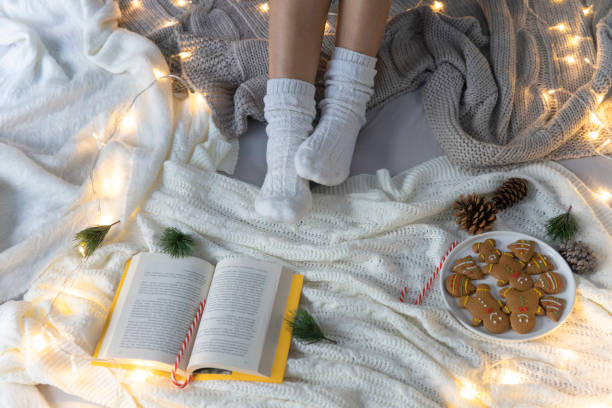 istock Young woman wearing woolen socks on cold winter weekend. Christmas, relaxation concept 1360683074