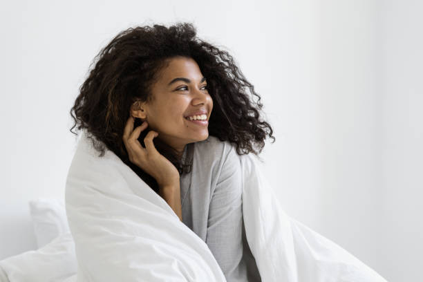 istock Happy dark skinned woman wrapped in a blanket 1360685079
