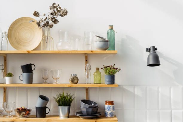 istock Wooden shelves with utensils in modern kitchen with white wall 1360685218