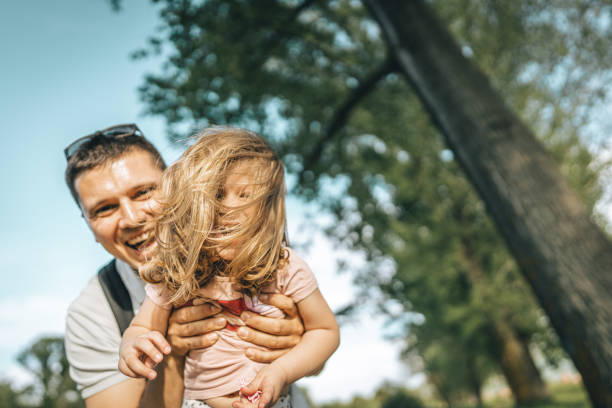 istock Father laughing and playing with his daughter in nature 1360689003