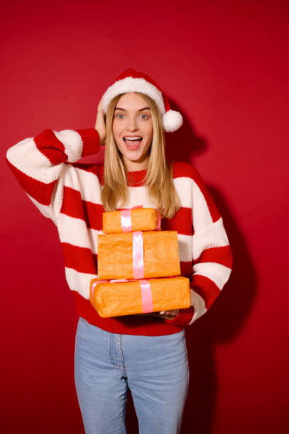 istock A girl in striped sweater holding many gift boxes 1360689097