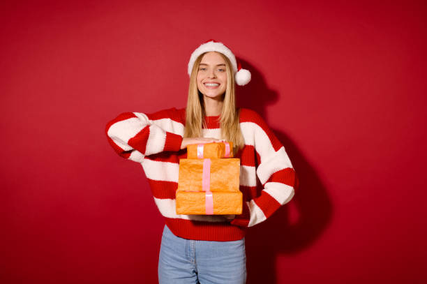 istock A girl in striped sweater holding many gift boxes 1360689098