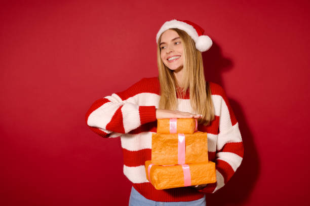 istock A girl in striped sweater holding many gift boxes 1360689100