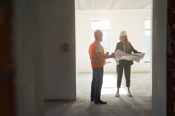 istock Worker bringing coffee to female engineer with drawings 1360691175