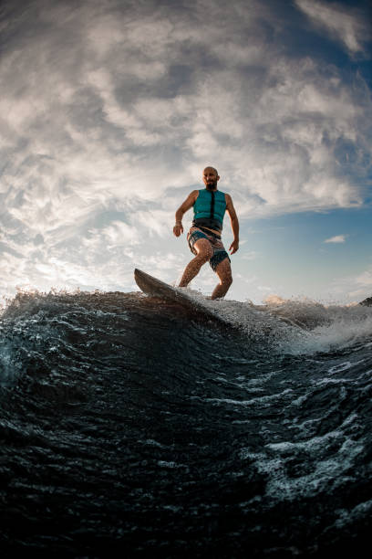 istock man wakesurfer actively balancing on wakeboard along the river wave 1360693038