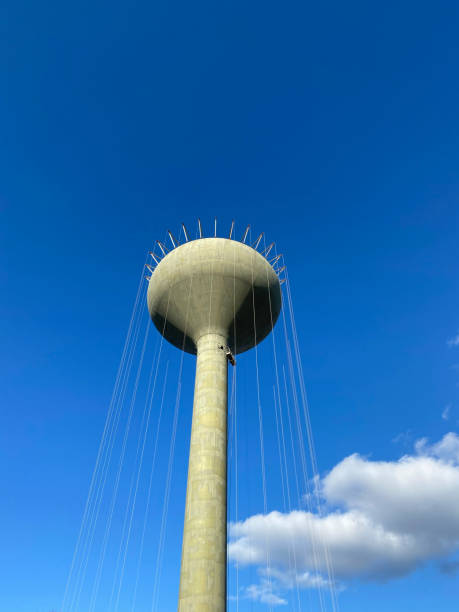 istock Water tower under construction with cover cables hanging with clouds and copy space 1360693120