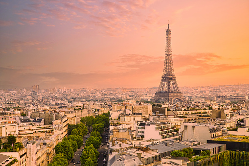 The Eiffel tower in the Paris skyline during an vibrant orange sunset.