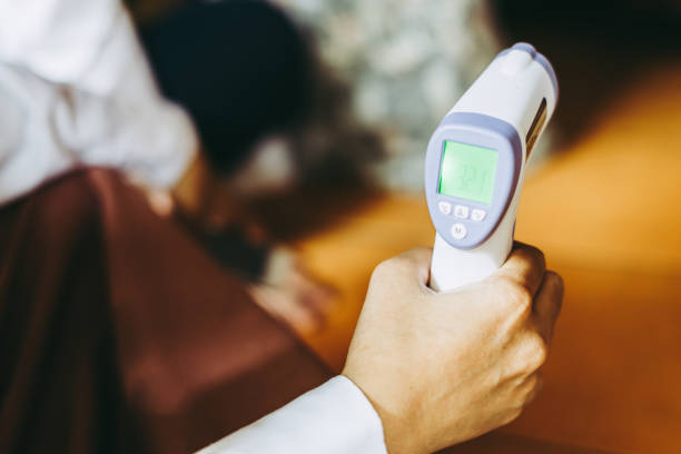 istock Hand holding thermogun or thermometer 1360695365