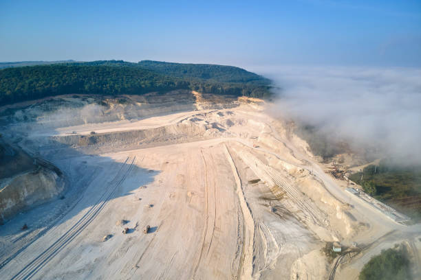 istock Aerial view of open pit mining of limestone materials for construction industry with excavators and dump trucks. 1360696414