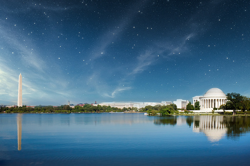 The Washington Monument and Jefferson Memorial in Washington DC reflecting over the waters of the Potomac river at night.
