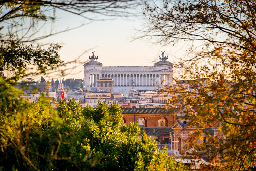 A beautiful view over the rooftops of Rome seen from the Pincio Gardens viewpoint, in the historic center of the Eternal City. In the center the imposing facade of the Altare della Patria National Monument. The terrace viewpoint of the Pincio Gardens, one of the most visited and loved places in Rome, is the culmination of the west side of Villa Borghese, the largest public park of the Italian capital. From this belvedere you can enjoy a breathtaking 180 degree view of the historic center of Rome, in the setting of some of the most beautiful gardens in the city. The Altare della Patria or Vittoriano is the Italian National Monument built in 1885 in neoclassical style between the Campidoglio (Roman Capitol) and Piazza Venezia in honor of the first king of Italy, Victor Emmanuel II, to celebrate the definitive unification of Italy which took place in 1870. Subsequently, after the end of the First World War, the tomb of the Unknown Soldier was placed inside it as a military shrine dedicated to all the Italian soldiers who died in the war. Every year the Altare della Patria is the setting for all Italian civic celebrations, in particular the National Day of the Republic on 2 June and the Liberation Day on 25 April. In 1980 the historic center of Rome was declared a World Heritage Site by Unesco. Image in high definition format.