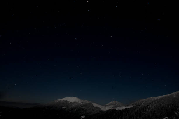 istock Dark night starry sky over mountain top covered with snow. 1360698360