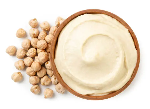 Hummus in a plate and chickpeas close-up on a white background, isolated. Top view