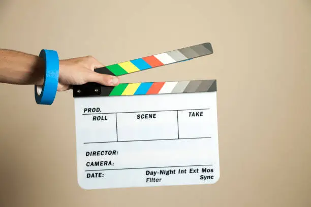 A hand holding clapperboard with a production tape on the wrist. Clapperboard concept. filming concept. Copy space.