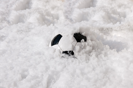Soccer ball buried in snow