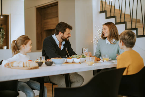 istock Young happy family talking while having breakfast at dining table 1360715990