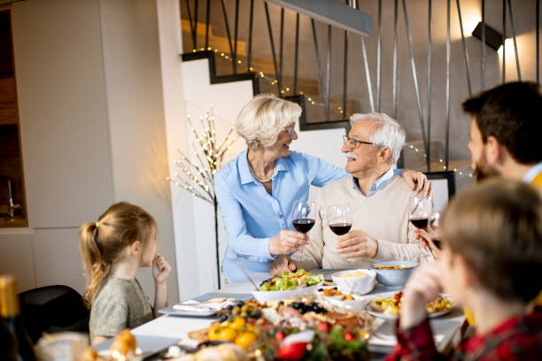 istock Happy family having dinner with red wine at home 1360716003