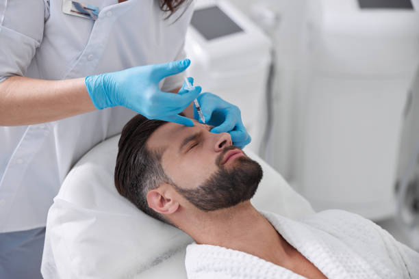 istock Client undergoes painful procedure of eyebrow lifting while cosmetologist does injection in clinic 1360716163