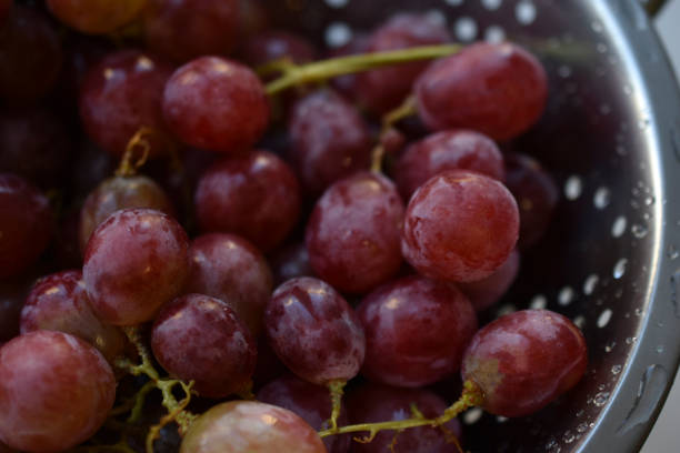 istock Freshly washed red grapes in a colander 1360717568