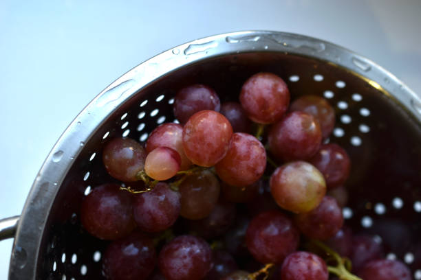 istock Freshly washed red grapes in a colander 1360717576