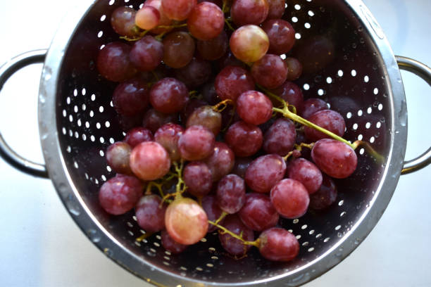 istock Freshly washed red grapes in a colander 1360717577