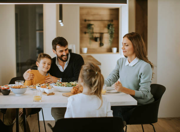 istock Young happy family talking while having lunch at dining table 1360718326