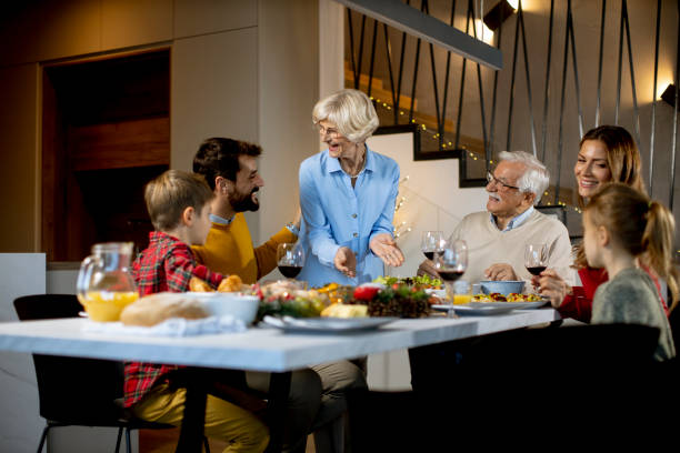 istock Happy family having dinner with red wine at home 1360718422